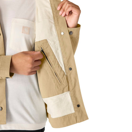 Close-up of a person wearing a beige jacket with an interior zipper pocket on a white background