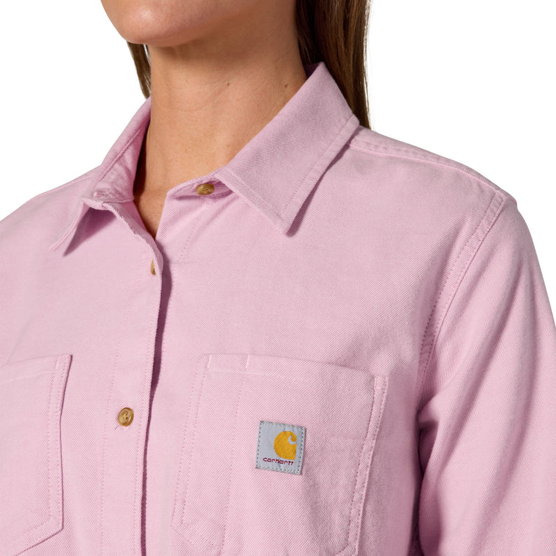Load image into Gallery viewer, Close-up of a model wearing a light pink Carhartt button-up shirt, showing the collar, front placket, chest pocket, and the Carhartt logo patch on the pocket.
