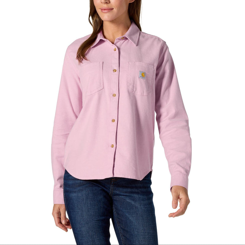 Load image into Gallery viewer, A woman modeling a light pink long-sleeve button-up shirt with a chest pocket and a small Carhartt logo on the left chest, paired with dark blue jeans against a plain white background.
