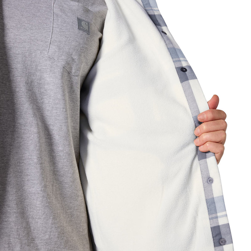Load image into Gallery viewer, Close-up of a person wearing a gray heathered shirt and holding open a white button-front overshirt with a blue-gray plaid lining, showing a small gray Carhartt logo patch.
