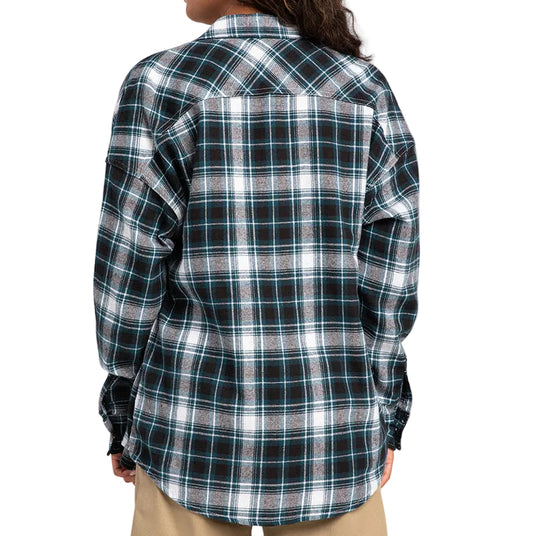 A person shown from the back wearing a long-sleeve plaid button-up shirt in black, white, and light blue over a beige shirt, against a plain light gray studio background.