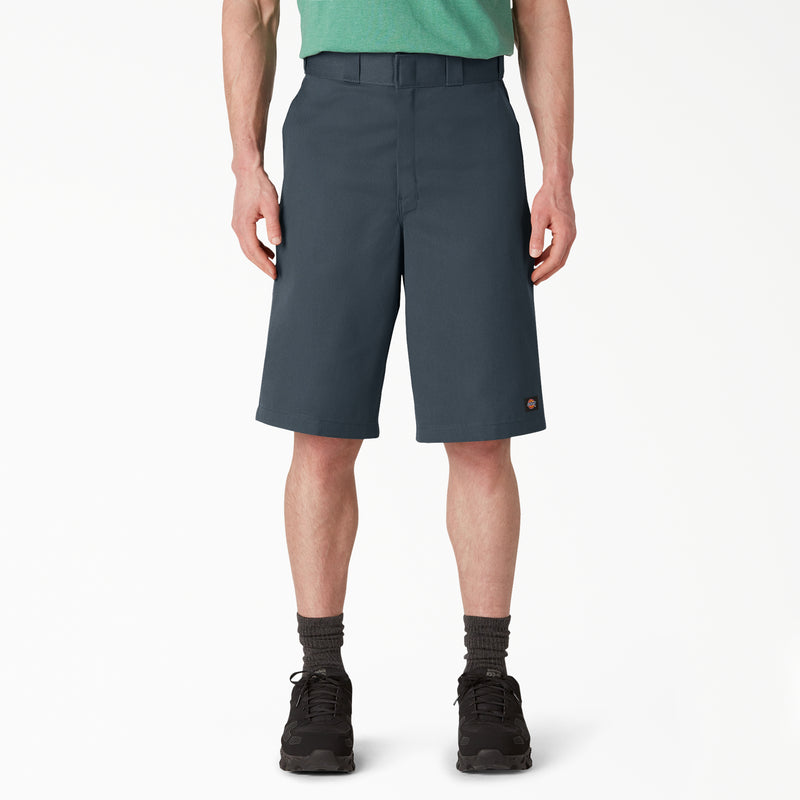 Load image into Gallery viewer, Person wearing dark gray Dickies shorts on a white background. 
