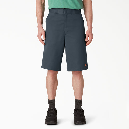 Person wearing dark gray Dickies shorts on a white background. 