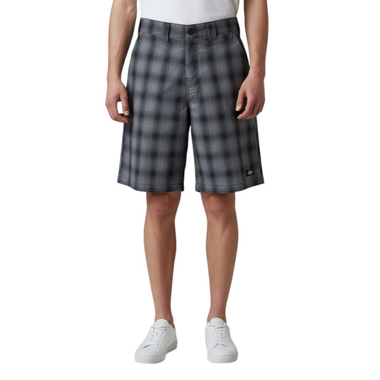 Person wearing black plaid shorts on a white background. 