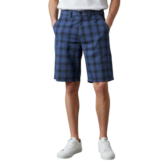 Person wearing blue plaid shorts on a white background.