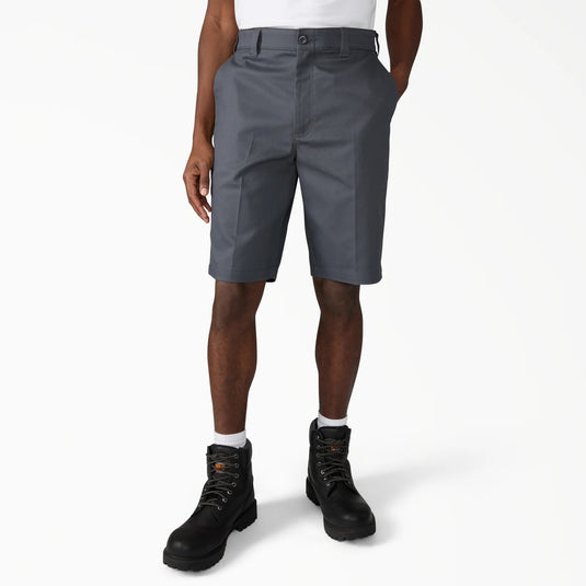Person wearing gray shorts and black boots on a white background