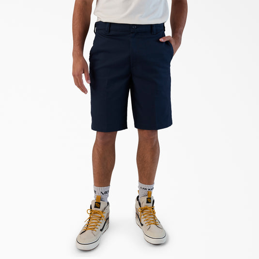 Person wearing navy shorts, white socks, and beige sneakers on a white background