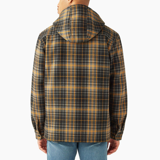 Man wearing a charcoal and orange plaid jacket on a white background