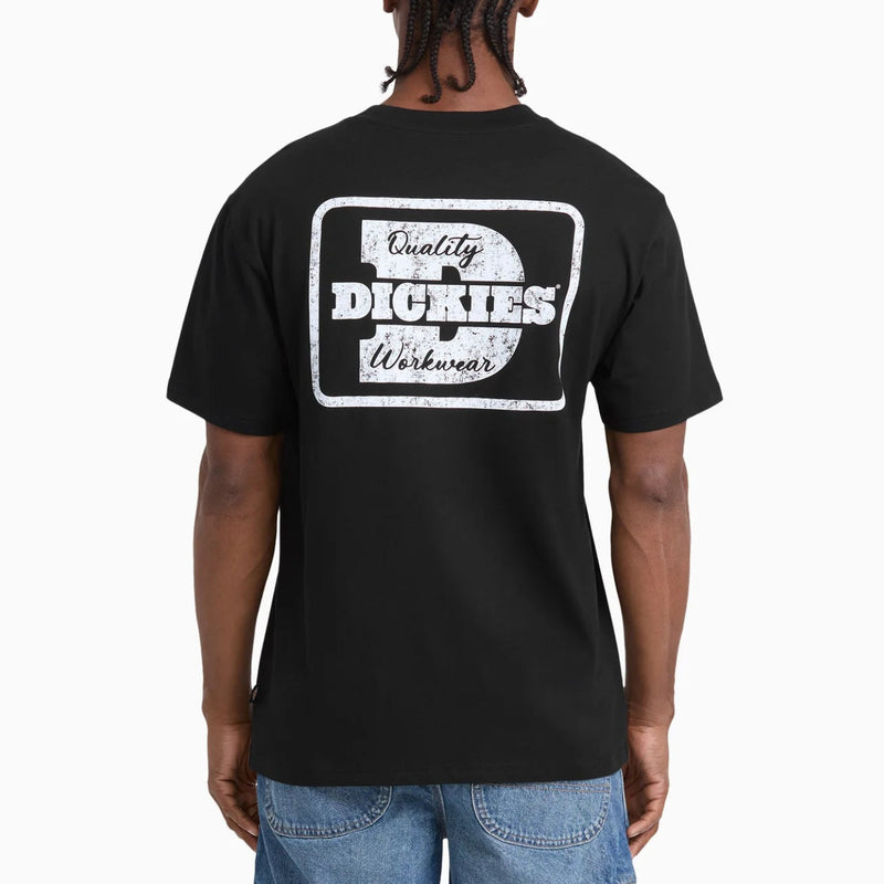 Load image into Gallery viewer, A man viewed from behind wearing a black short-sleeve t-shirt with a large distressed white graphic on the back that reads 'Quality Dickies Workwear' with an anvil icon, paired with blue jeans against a plain white background.
