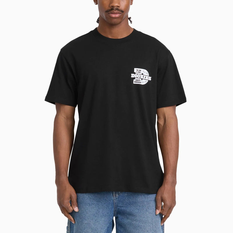 Load image into Gallery viewer, A man wearing a black short-sleeve t-shirt with a small white graphic on the left chest that reads 'DICKIES', paired with blue jeans, against a plain white background.
