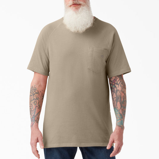 Person wearing a beige pocket tee on a white background. 