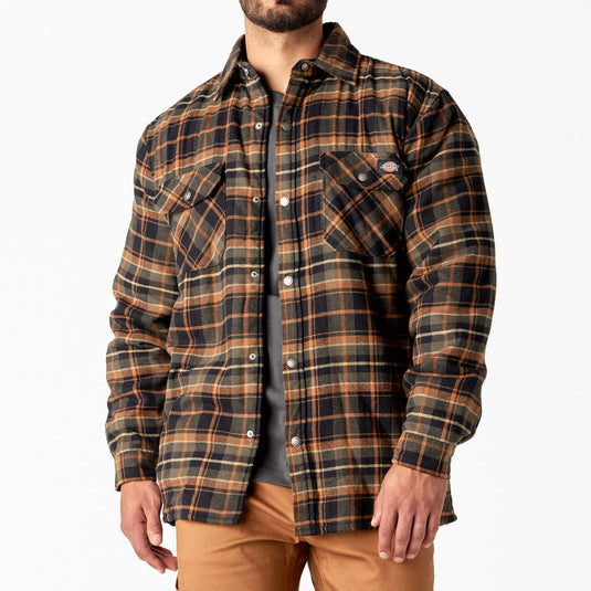 Man wearing a plaid shirt and tan pants on a white background