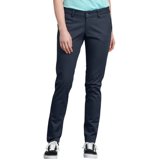 A person wearing slim-fit navy pants with a light blue top and black low-top sneakers, shown from the waist down on a plain white studio background.