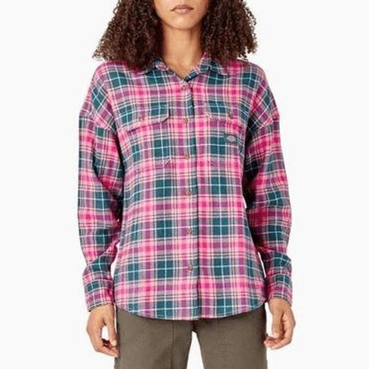 A woman modeling a long-sleeve button-up plaid shirt in pink, teal, and green, paired with olive pants, against a plain white background.
