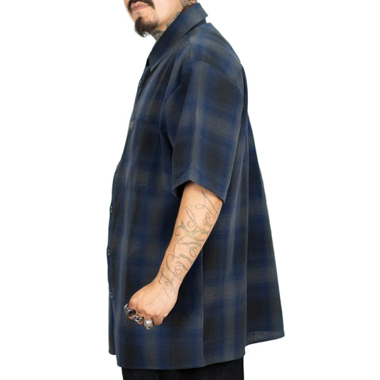 Man wearing a blue and grey short sleeve plaid shirt