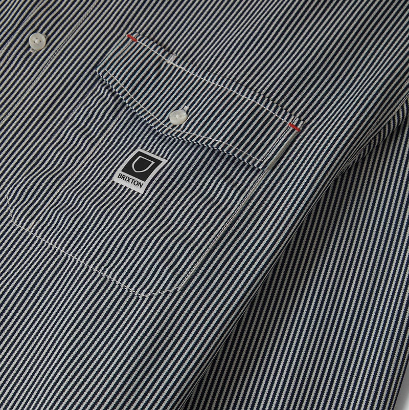 Load image into Gallery viewer, Close-up of a striped shirt with left front button-down flap pockets and a Brixton woven label.
