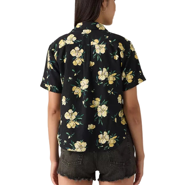 Load image into Gallery viewer, Back of a woman wearing a Levi's black floral shirt with yellow flowers 
