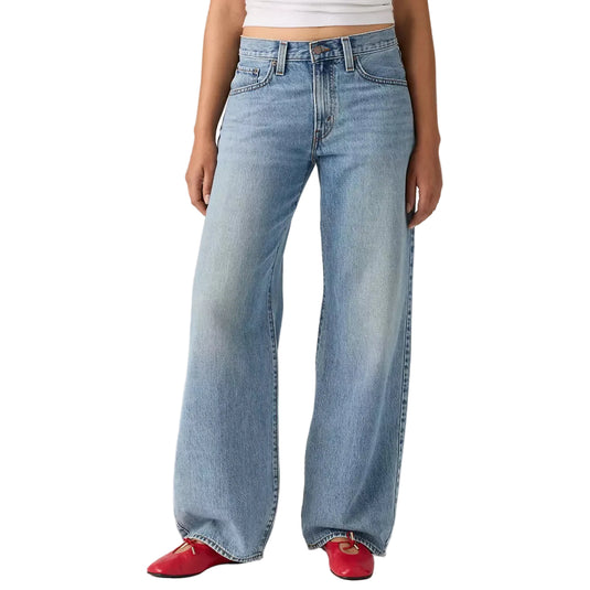 Person wearing light blue wide-leg jeans with a plain background
