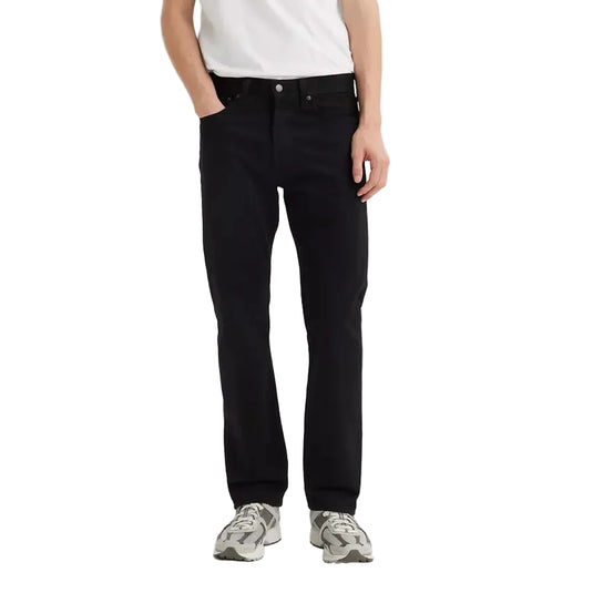 Man wearing a white t-shirt with black Levis 501 Original jeans on a white background