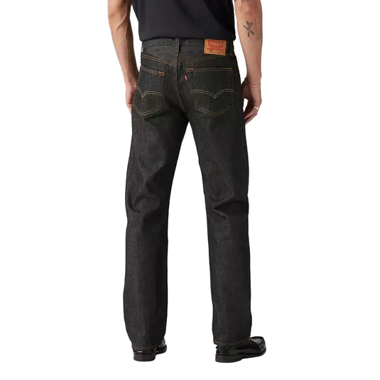Man wearing dark jeans and a black t-shirt on a plain background