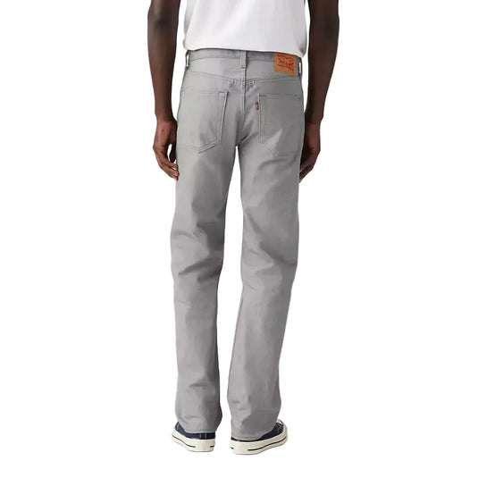 Person wearing gray jeans and a white t-shirt on a plain background
