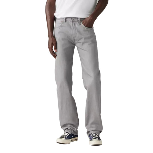 Man wearing a white t-shirt and gray jeans on a plain background