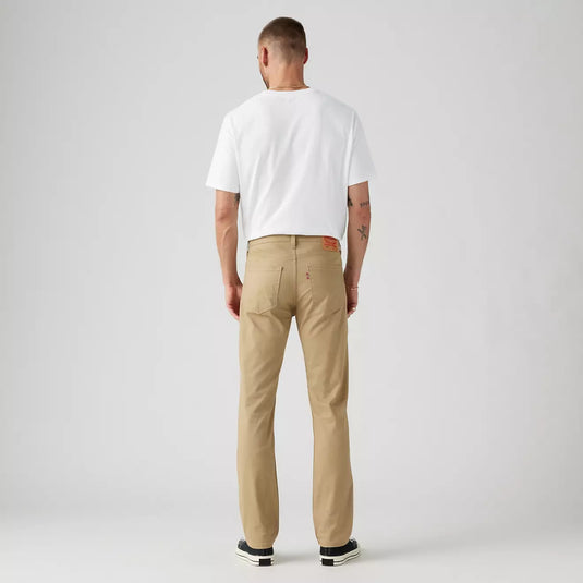 Man wearing a white t-shirt and beige pants on a plain background