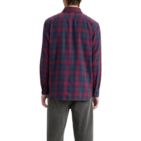 Person wearing a red and blue plaid shirt on a white background