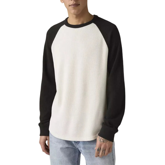 Man wearing a black and white long-sleeve thermal shirt against a plain background