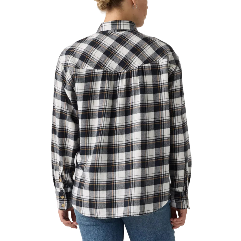 Load image into Gallery viewer, A woman viewed from the back wearing a black, white, and gray plaid flannel shirt with blue jeans, set against a plain light gray studio background.
