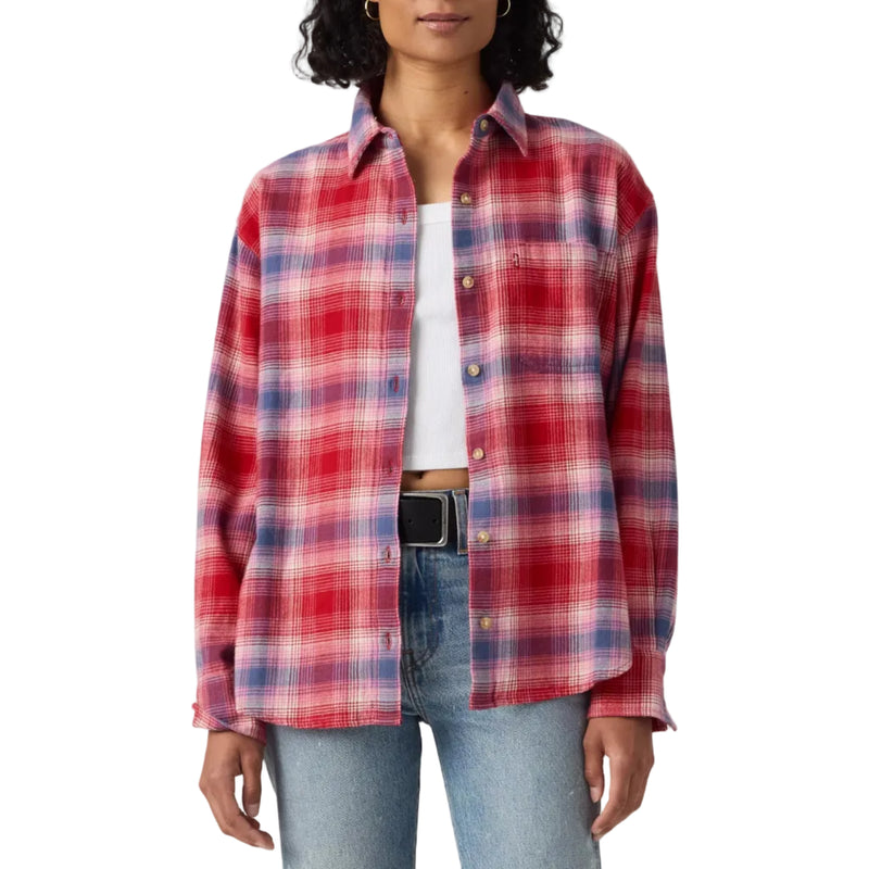 Load image into Gallery viewer, A woman modeling a red, pink, and blue plaid button-up shirt over a white top and light-wash blue jeans, standing against a plain light gray studio background.
