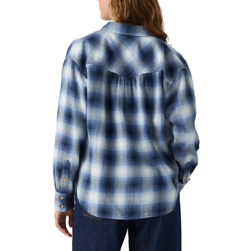 Load image into Gallery viewer, A woman shown from the back wearing a blue and white plaid western-style shirt and dark blue jeans, photographed against a plain light gray studio background.
