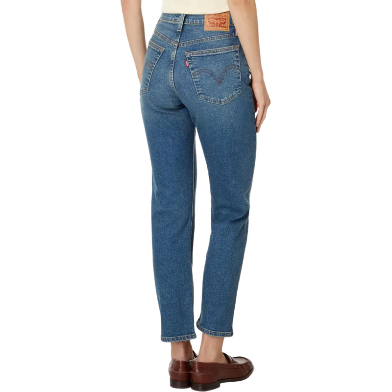 Load image into Gallery viewer, Rear view of a model wearing Levi's straight-leg blue jeans with brown leather loafers, on a white background.

