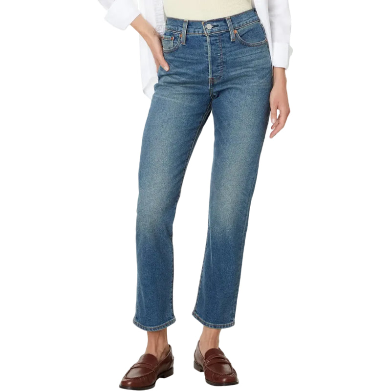 Load image into Gallery viewer, A model wearing a pair of medium-wash blue denim jeans with a straight-leg fit, styled with a white button-up shirt and brown leather loafers against a plain white background.
