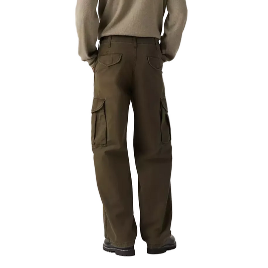 A model shown from the back wearing a beige knit sweater and dark brown cargo pants against a plain white studio background.