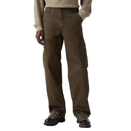 A person wearing dark brown cargo pants with a beige sweater and black lace-up shoes, shown from the chest down against a white studio background.