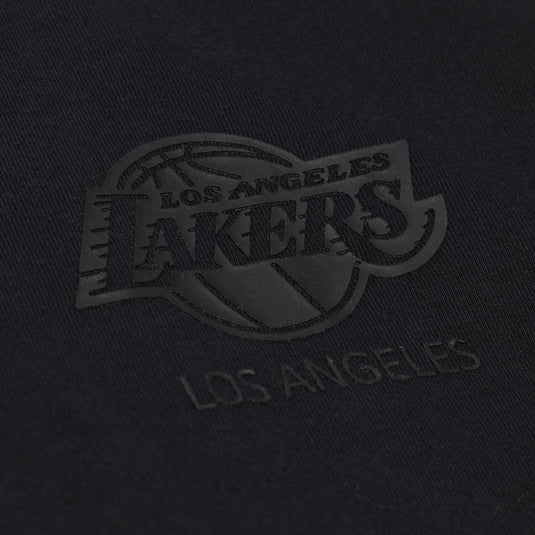 Close-up of a black fabric with a tonal, low-contrast Los Angeles Lakers logo patch and the words 'LOS ANGELES' below it.
