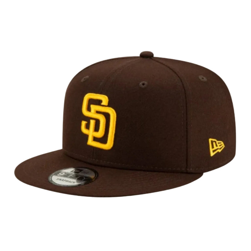 Load image into Gallery viewer, A dark brown San Diego Padres baseball cap by New Era, featuring a yellow embroidered 'SD' logo on the front and a yellow New Era flag logo on the side, set against a plain white background.
