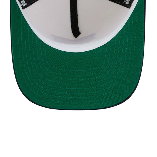Close-up of the front of a baseball cap showing a dark green curved brim, a white inner crown, and black adjustable strap hardware.