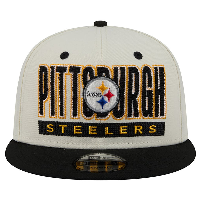 Load image into Gallery viewer, A Pittsburgh Steelers fitted baseball cap featuring a cream-colored crown with black embroidered lettering outlined in gold, a central Steelers logo patch, and a black flat brim.
