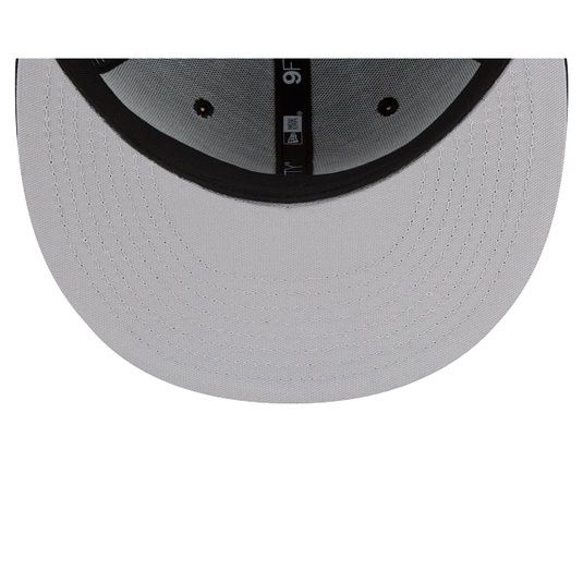 Close-up of the underside of a light gray baseball cap brim, showing black stitched edge and ventilation eyelets, with a small New Era logo visible on the center band.