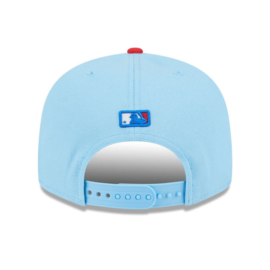 Back of a light blue baseball cap with the MLB logo above the snapback closure. 