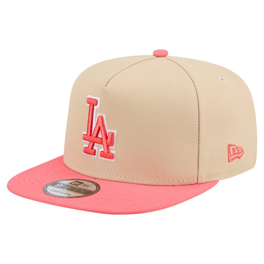 A New Era Los Angeles Dodgers 9FIFTY fitted cap featuring a beige crown with a red embroidered 'LA' logo and a bright coral pink flat brim.