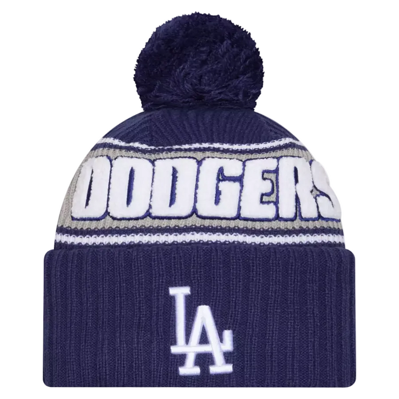 Load image into Gallery viewer, A navy blue knit beanie with a matching pom-pom, featuring the word 'DODGERS' in white across the upper portion, a thin gray stripe, and the white 'LA' logo on the folded cuff.
