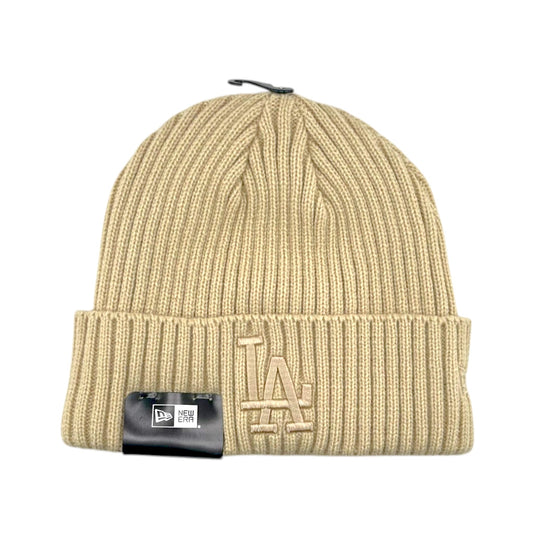 A beige ribbed knit beanie hat with a folded cuff, featuring a tonal beige LA logo on the front and a black hangtag attached near the bottom left.