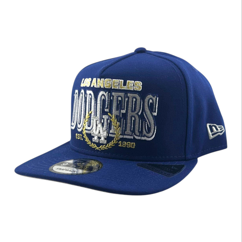 Load image into Gallery viewer, A royal blue Los Angeles Dodgers baseball cap by New Era, featuring white and gold embroidered lettering on the front panel and a silver brim.
