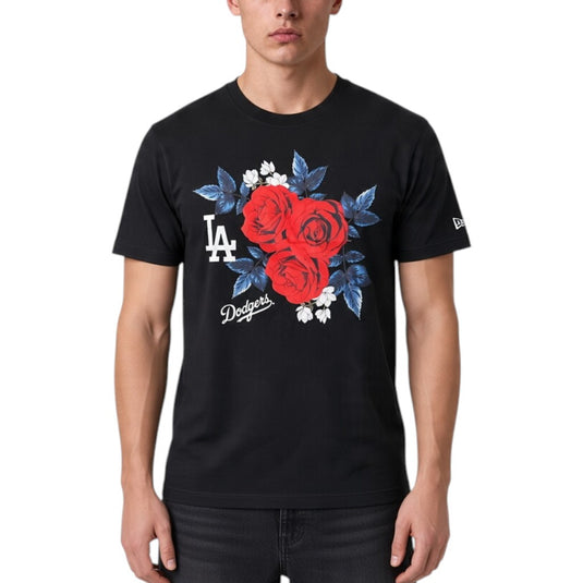 A man wearing a black Los Angeles Dodgers t-shirt with a red rose and blue leaf graphic on the front, paired with black jeans, against a plain white background.