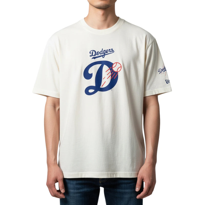 Load image into Gallery viewer, A man wearing a cream-colored Los Angeles Dodgers t-shirt with a blue and red graphic on the front, paired with dark blue jeans, against a plain white background.
