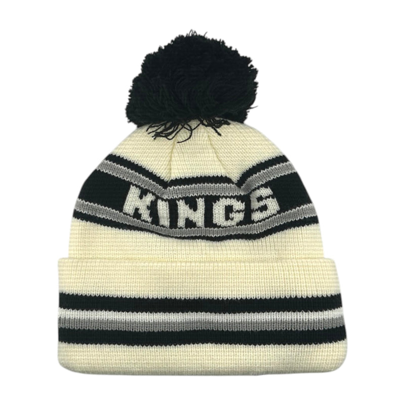 Load image into Gallery viewer, A knit pom-pom beanie hat in cream with black and gray stripes, featuring the word 'KINGS' knitted across the front and a black pom-pom on top, shown against a plain white background.
