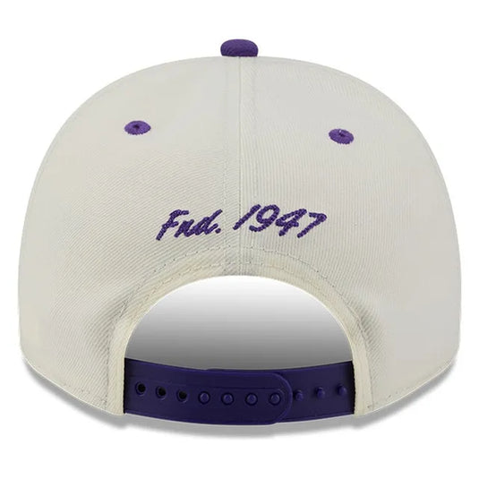 Back view of a white baseball cap with purple embroidery reading 'Fnd. 1947' and purple adjustable strap.